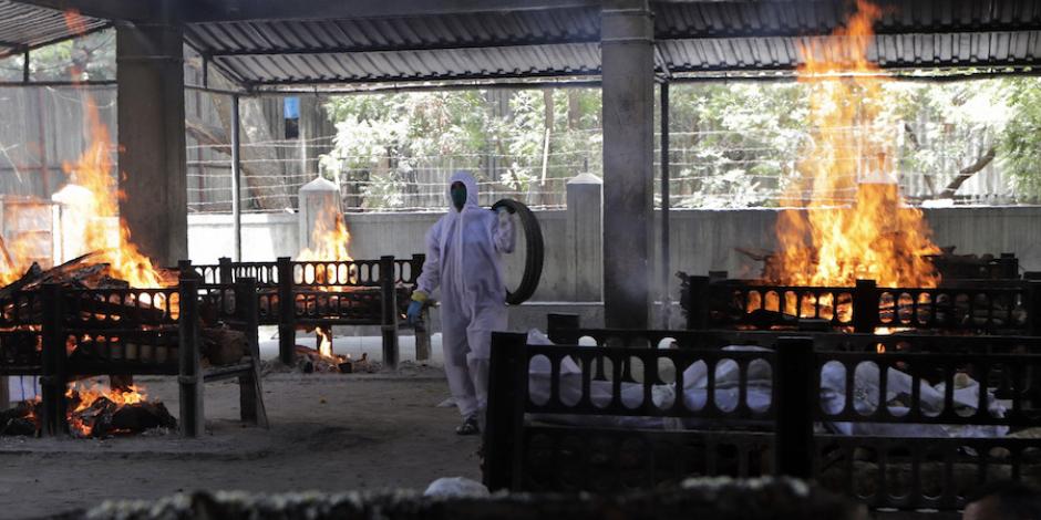 Un empleado supervisa la cremación de las víctimas de un incendio, ayer, en India.