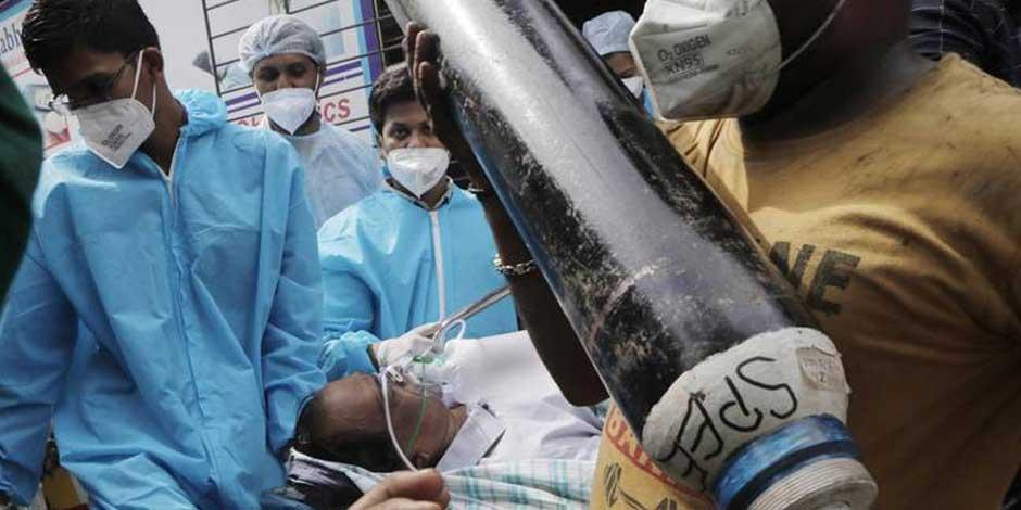 Trabajadores de la salud llevan a un paciente COVID, cerca de Mumbai, India