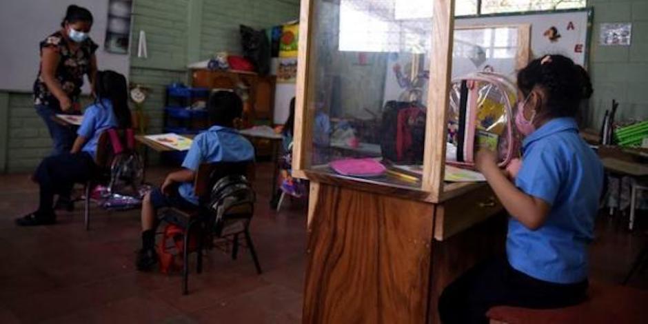William López, de El Salvador, se dio a la tarea de construir un pupitre especial para cuidar a su hija de 6 años de edad del COVID-19. Foto: EFE