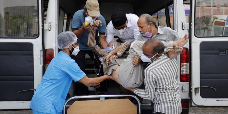 Familiares y personal médico ayudan a ingresar a un enfermo al hospital en Ahmedabad, ayer.
