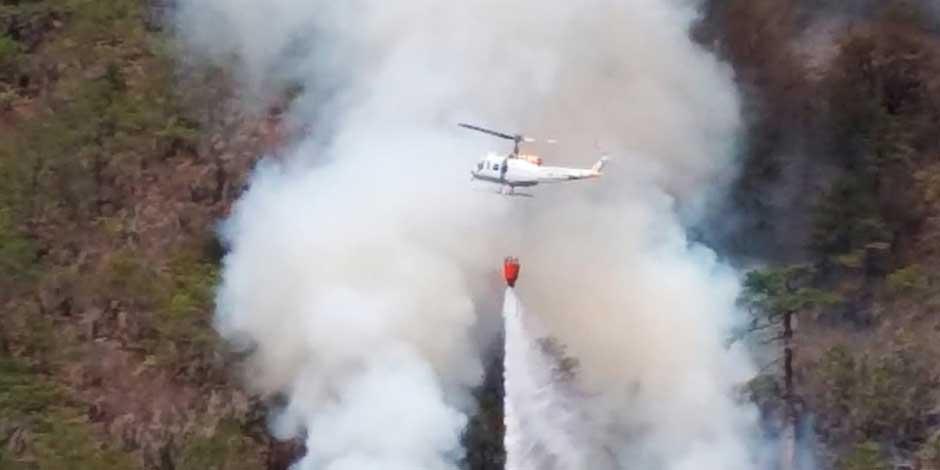 En la imagen, un helicóptero en labores de combate a incendios forestales