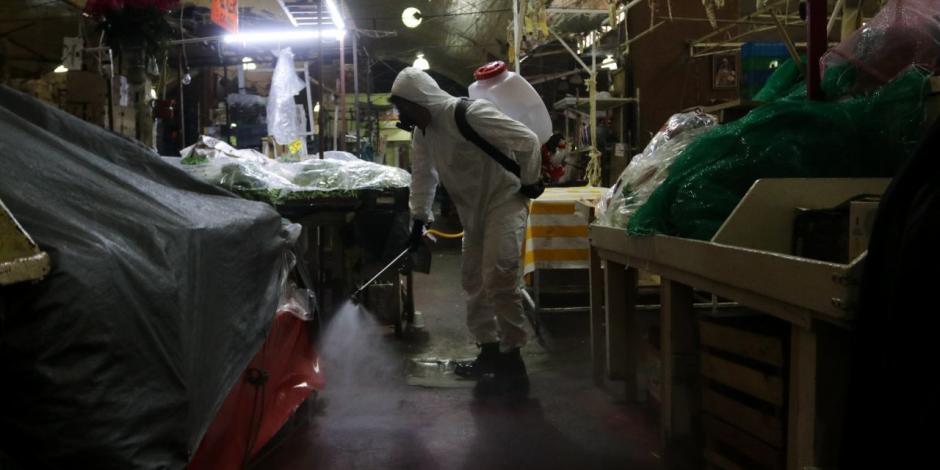 Trabajadores de la CDMX realizan la labor de desinfección al interior del mercado la Merced.