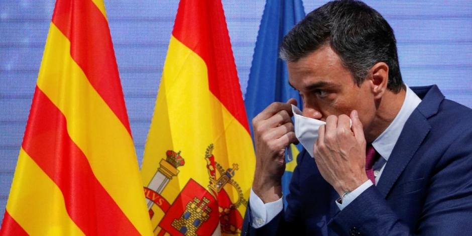 El presidente del gobierno español, Pedro Sánchez, se quita el cubrebocas antes de anunciar que su uso dejará de ser una medida obligatoria en lugares públicos de España.