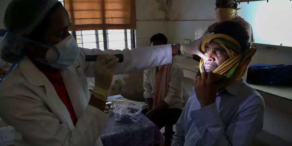 Una médica india revisa a un hombre que se recuperó de COVID-19 y que ahora está infectado con la enfermedad del "hongo negro" en la sala de Mucormicosis de un hospital gubernamental en Hyderabad, India, el jueves 20 de mayo de 2021
