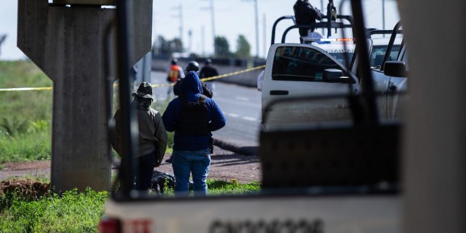 Elementos de la Guardia Nacional resguardan la escena donde fue localizado este lunes el cuerpo de una persona a un costado de la carretera federal 45 en la comunidad de Cieneguillas.