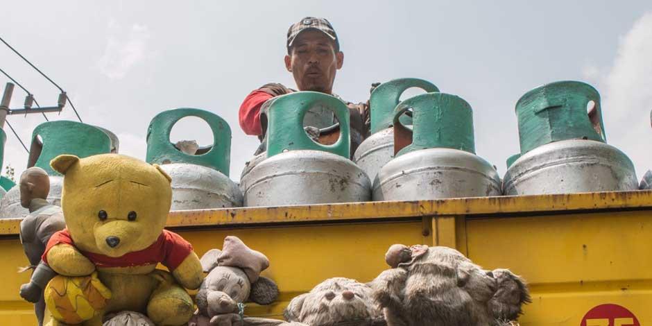 Un repartidor de gas en el barrio de Tepito cuelga monos de peluche en su camión
