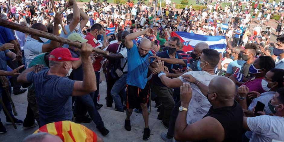 Personas se enfrentan a policías durante manifestaciones a favor y en contra del gobierno de Cuba
