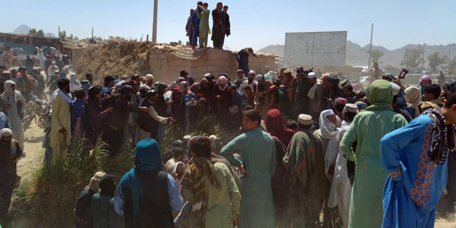 Afganos rodean a un agente de las  Fuerzas Armadas, atacado, el pasado 11 de agosto.