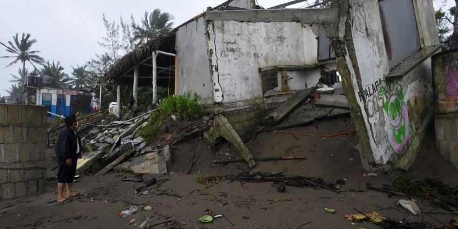 Un hombre parado frente a los bares de la playa dañados que fueron destruidos cuando el huracán Grace azotó Costa Esmeralda, en Veracruz.
