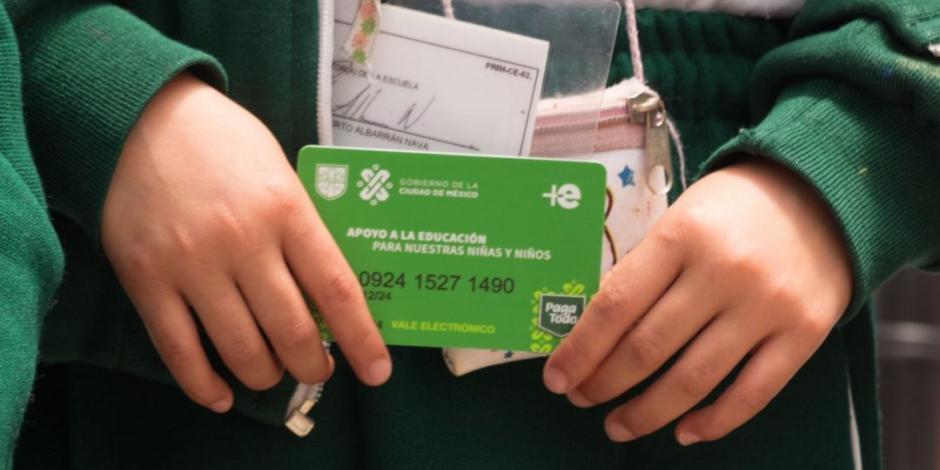 Una estudiante sostiene su tarjeta donde se deposita el apoyo de "Mi Beca para Empezar".