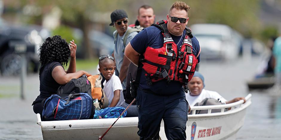 Rescatistas ayudan con lanchas a la población afectada en vecindarios de Louisiana, ayer.