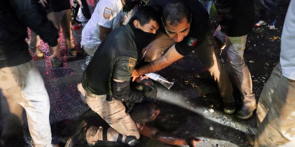 Agentes del INM capturan a un migrante durante un operativo para frenar el avance de una caravana, ayer, en Chiapas.