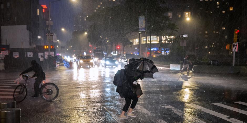 Personas caminan en calles de Nueva York pese a las fuertes lluvias y vientos provocados por el huracán "Ida"