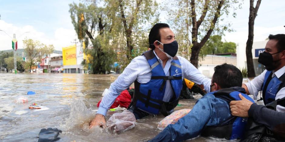 En una imagen compartida por Omar Fayad, se puede ver al mandatario estatal con el agua hasta la cintura junto a otras dos personas que buscan ponerse a salvo de la inundación