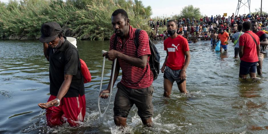 Migrantes que buscan asilo en EU caminan sobre el río Bravo, en Ciudad Acuña.
