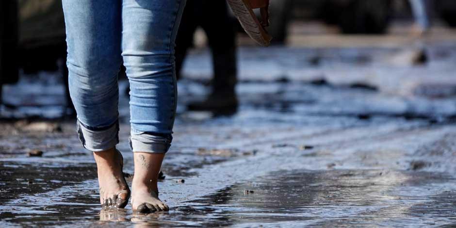 Un mujer camina sin zapatos sobre el lodo, residuo de la inundación de septiembre en Ixmiquilpan, Hidalgo.