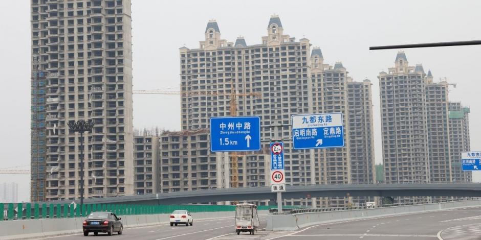 Los vehículos pasan por edificios residenciales sin terminar del Evergrande Oasis, un complejo de viviendas desarrollado por Evergrande Group, en Luoyang, China, el 16 de septiembre de 2021.