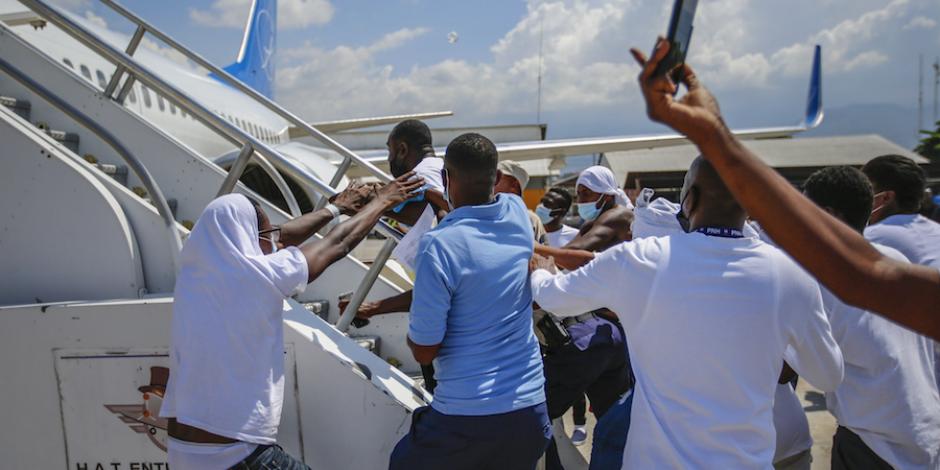 Haitianos deportados intentan abordar de nuevo el avión en el que llegaron a Puerto Príncipe, ayer.