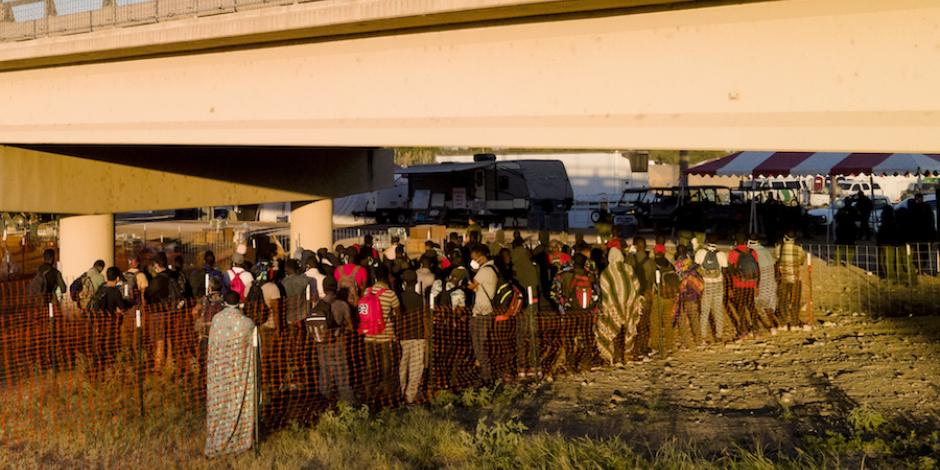 Migrantes hacen fila para subir a los autobuses en Texas.