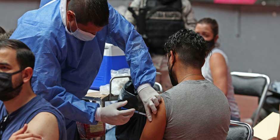 Una persona encargada de la inoculación aplica la vacuna contra COVID a personas de 30-39 años en México.