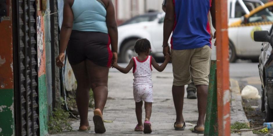 Una familia de haitianos camina en los alrededores del albergue Casa INDI en Monterrey.