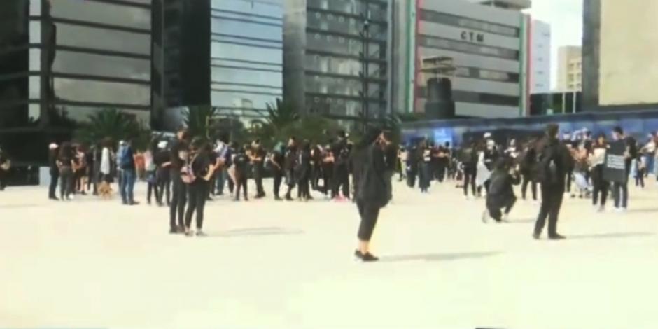 Mujeres y hombres vestidos de negro en la explanada del Monumento a la Revolución.