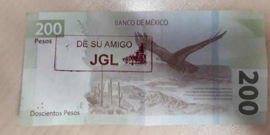 Billete de 200 pesos sellado con un sello con la leyenda "De su amigo JGL".