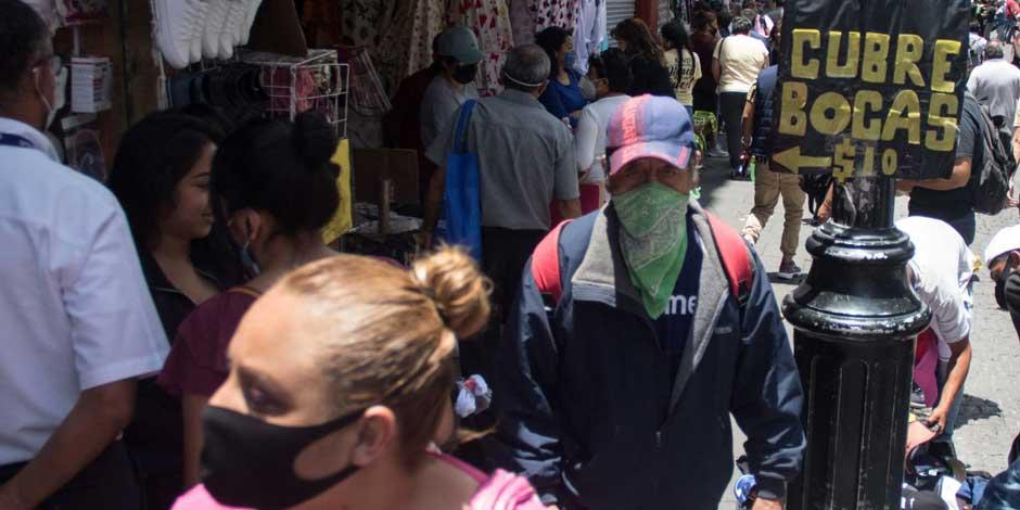 Personas caminan en las calles del Centro Histórico de la Ciudad de México, donde la venta de cubrebocas contra el COVID-19 sigue en auge