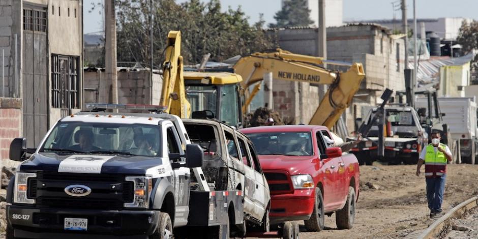 Autos calcinados fueron retirados ayer de la zona cero en Xochimehuacan, Puebla.
