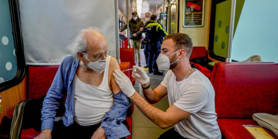 Personal sanitario vacuna a pasajeros en un tren, en Alemania.