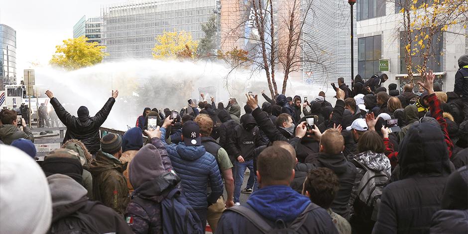 Con chorros de agua, policías dispersan a manifestantes en Países Bajos, ayer.