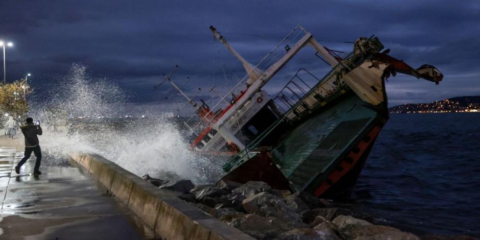 Un hombre toma una fotografía de uno de los barcos que quedaron encallados en las costas del Mar de Mármara después de que vientos extremos los empujaron de sus amarres, en Estambul, Turquía.