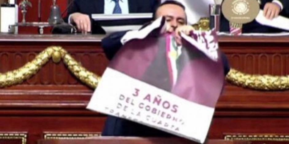 El diputado del PAN, Ricardo Rubio Torres, al momento de romper el cartel con la imagen de AMLO en el Congreso de la Ciudad de México.