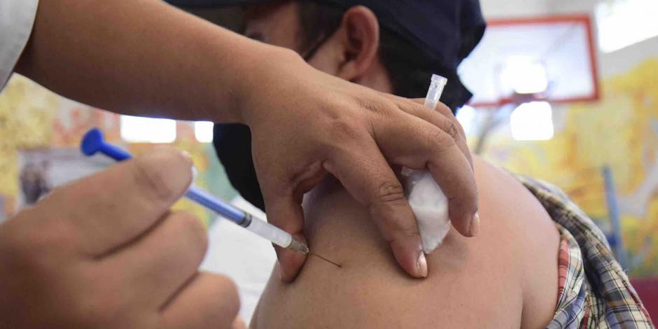 Personal de salud aplica una vacuna contra COVID-19  en el brazo izquierdo de un hombre que usa cubrebocas. La CDMX alista dosis de refuerzo para la población