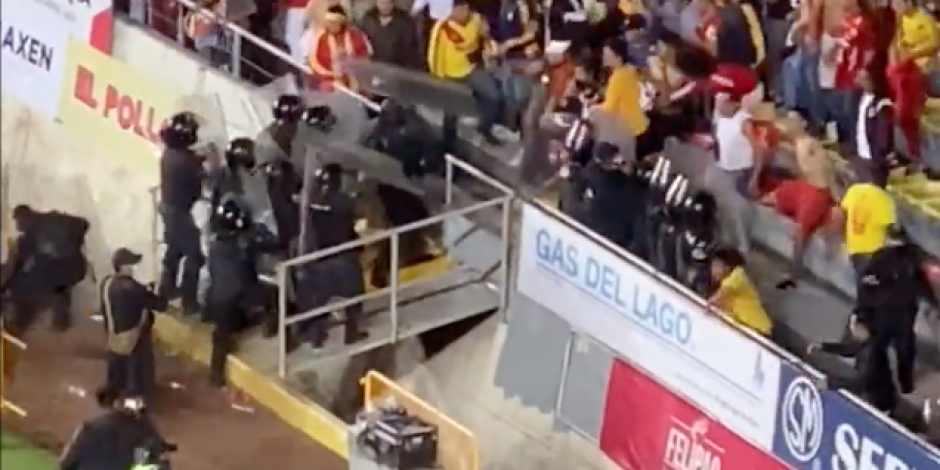 Momento exacto en el que aficionados del Atlético Morelia avientan objetos y agarran a golpes a policías en el Estadio Morelos.
