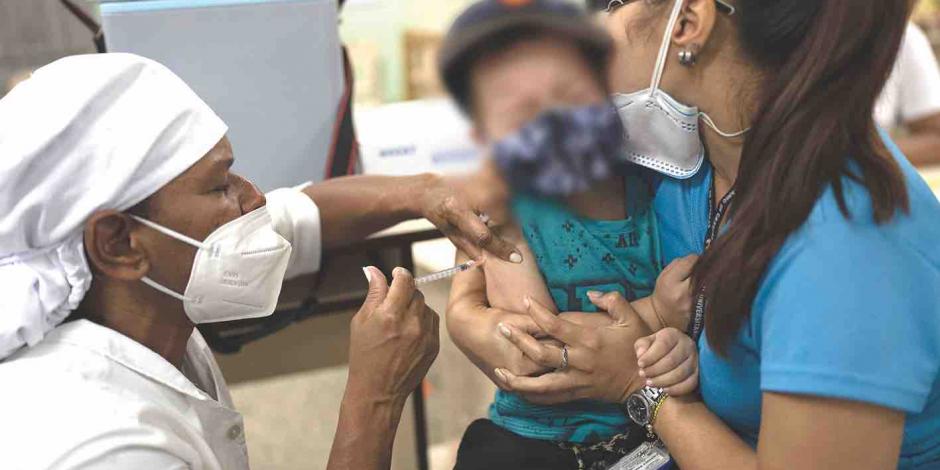 Un menor de seis años es abrazado por su mamá al momento de recibir su vacuna anti-Covid, ayer, en América Latina.
