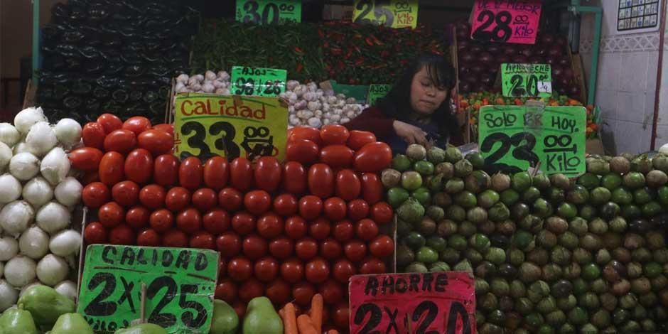 En la imagen, una mujer comerciante acomoda sus legumbres y verduras para venderlas.  El Inegi reportó que