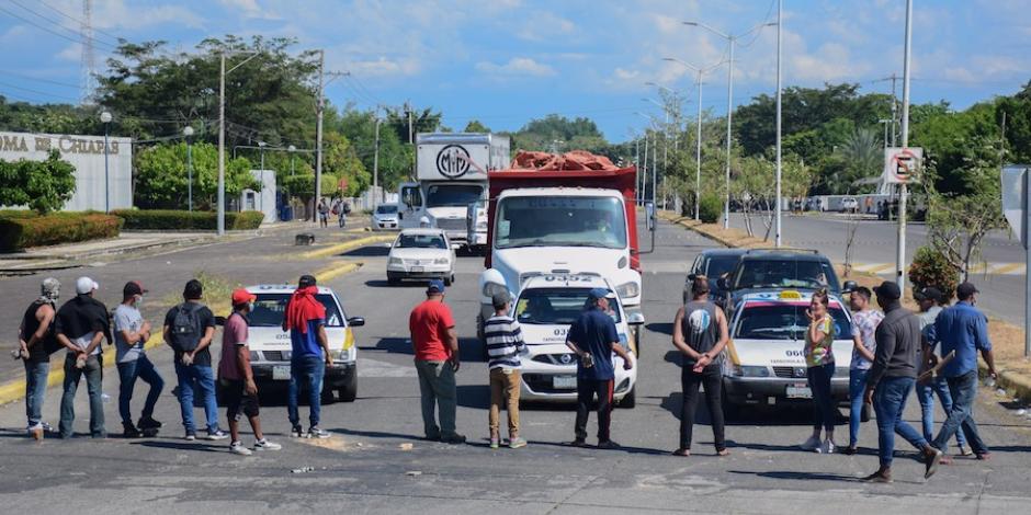 Un centenar de personas, centroamericanas y haitianas, bloquearon por varias horas la carretera Antiguo Aeropuerto, en Tapachula, para demandar ser trasladados a alguna de las 10 entidades del país donde se realizan los trámites migratorios. Los manifestantes acusaron que los agentes del INM les cobran hasta 200 dólares para dejarlos subir a los camiones.