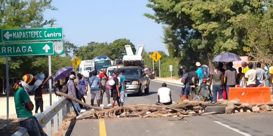 Migrantes centroamericanos bloquearon la carretera federal en Mapastepec, Chiapas, para exigir transporte y documentación al INM.