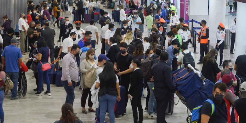 Cientos de personas atestan los pasillos del aeropuerto de la CDMX, para viajar.