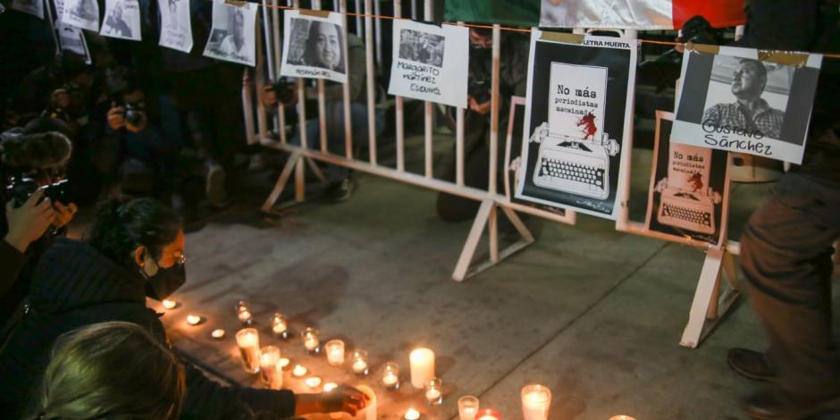 Periodistas ponen veladoras ante las imágenes de colegas asesinados en años recientes.