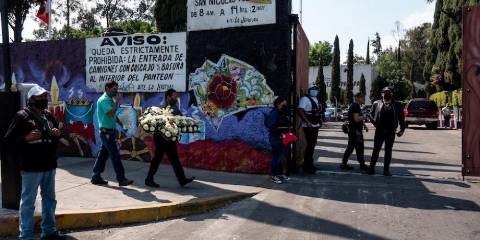 Personas llevan flores al panteón de San Nicolás Tolentino, en Iztapalapa, de donde fue exhumado el bebé Tadeo.