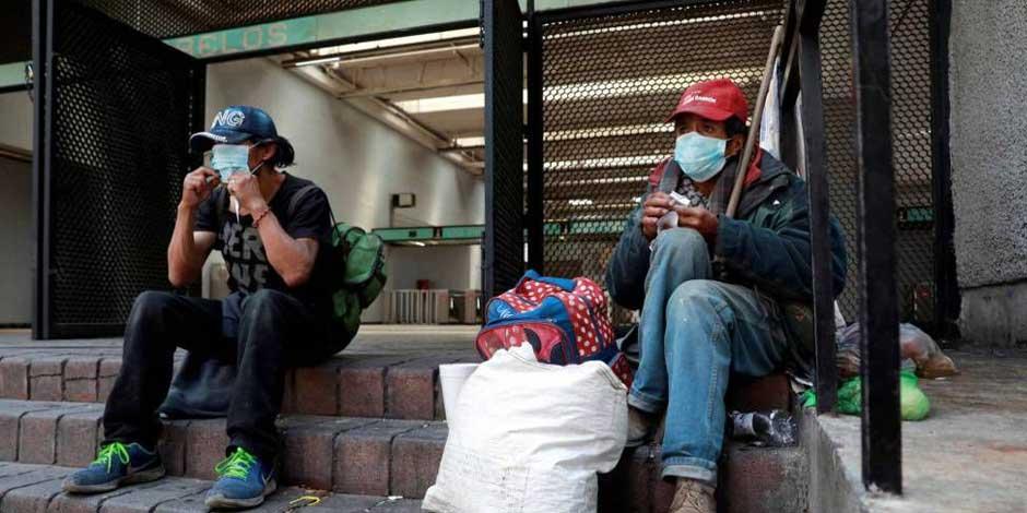 Personas sin hogar sentadas en la entrada del Metro Morelos utilizan cubrebocas para protegerse del COVID-19