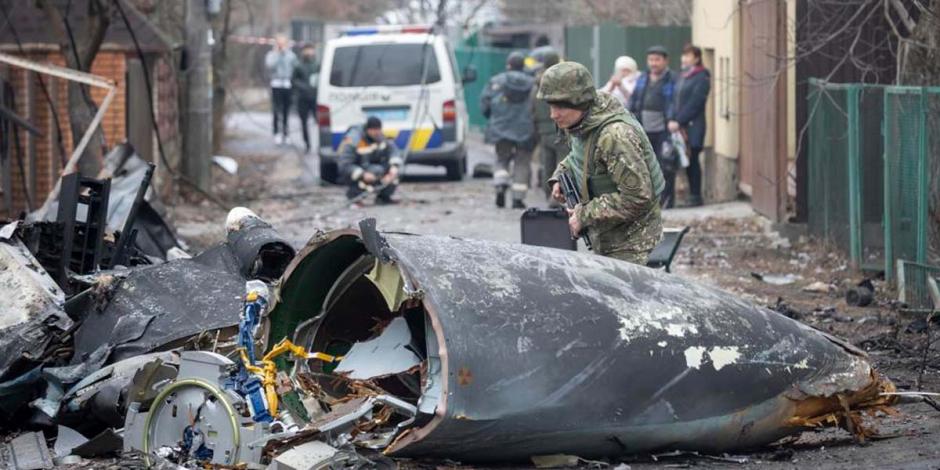Un soldado ucraniano inspecciona los restos de un avión derribado, el viernes 25 de febrero de 2022