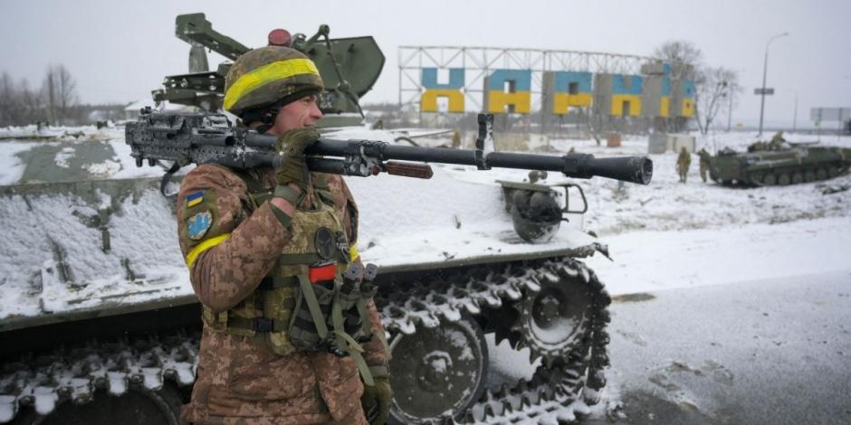 Un militar ucraniano sostiene un arma en su hombro mientras monta guardia en una carretera en Jarkov, Ucrania.