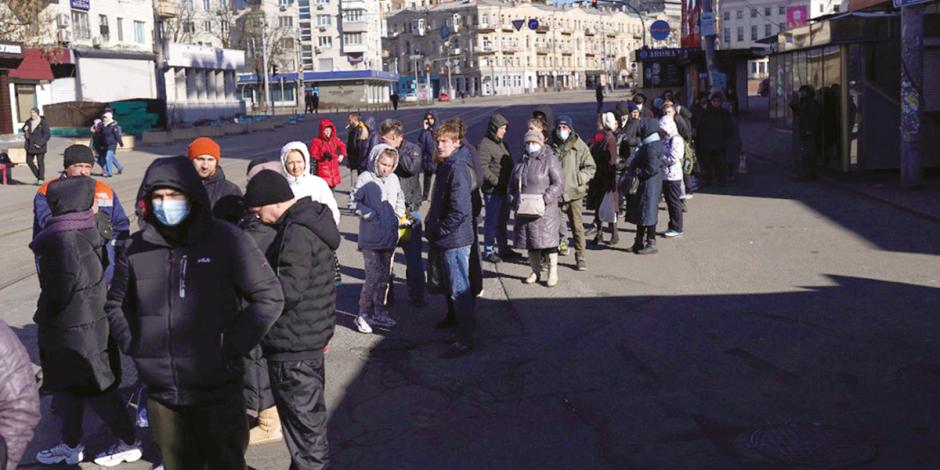 Decenas de personas se conglomeran a las afueras de un banco en Moscú.