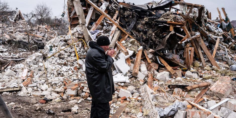 Un residente local fuma en los restos de un edificio residencial destruido por los bombardeos, como parte de los estragos de la invasión rusa en Ucrania.