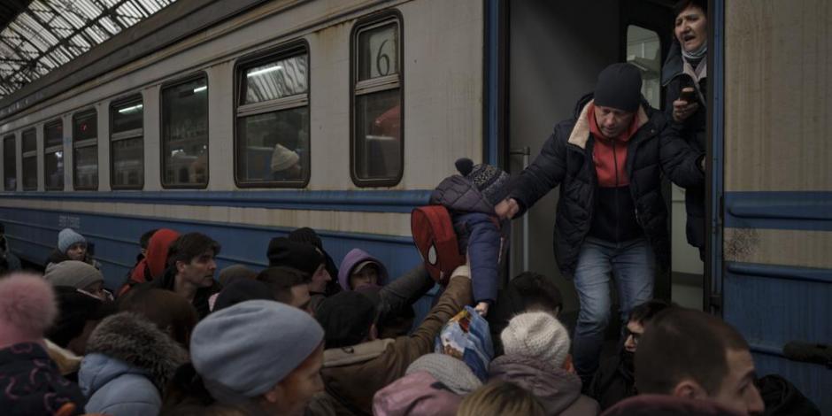 Ucranianos se apresuran a abordar un tren que parte rumbo a Eslovaquia desde la estación ferroviaria de Leópolis, al oeste de Ucrania.