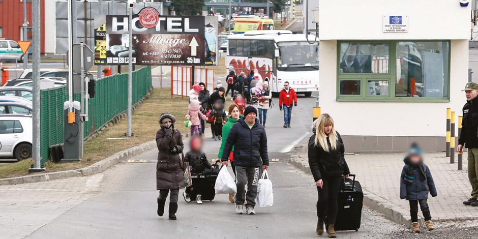 A pie y con apenas una maleta, ucranianos cruzan hacia Polonia, ayer.