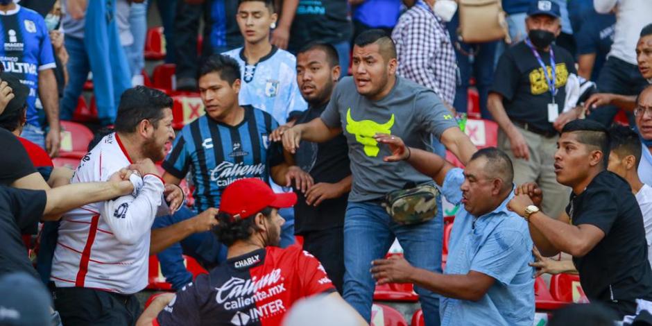 Aficionados del Querétaro y del Atlas riñen durante un partido de la Liga MX, en el Estadio Corregidora.